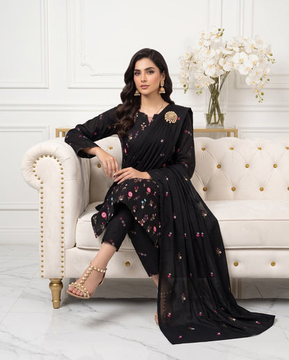 Model wearing a classic black premium Airjet Dhanak unstitched suit with vibrant floral embroidery from Aneela's Winter Collection.