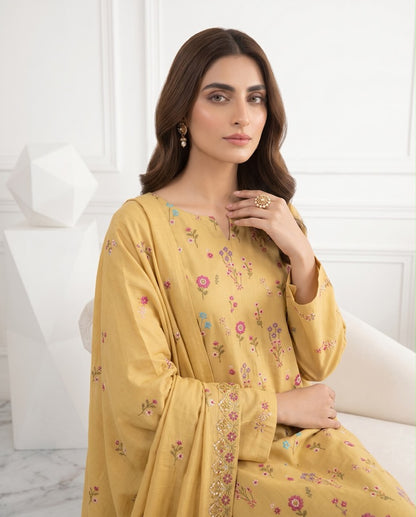 Mustard yellow premium Airjet Dhanak unstitched suit with vibrant floral embroidery from Aneela's Winter Collection, worn by a model.